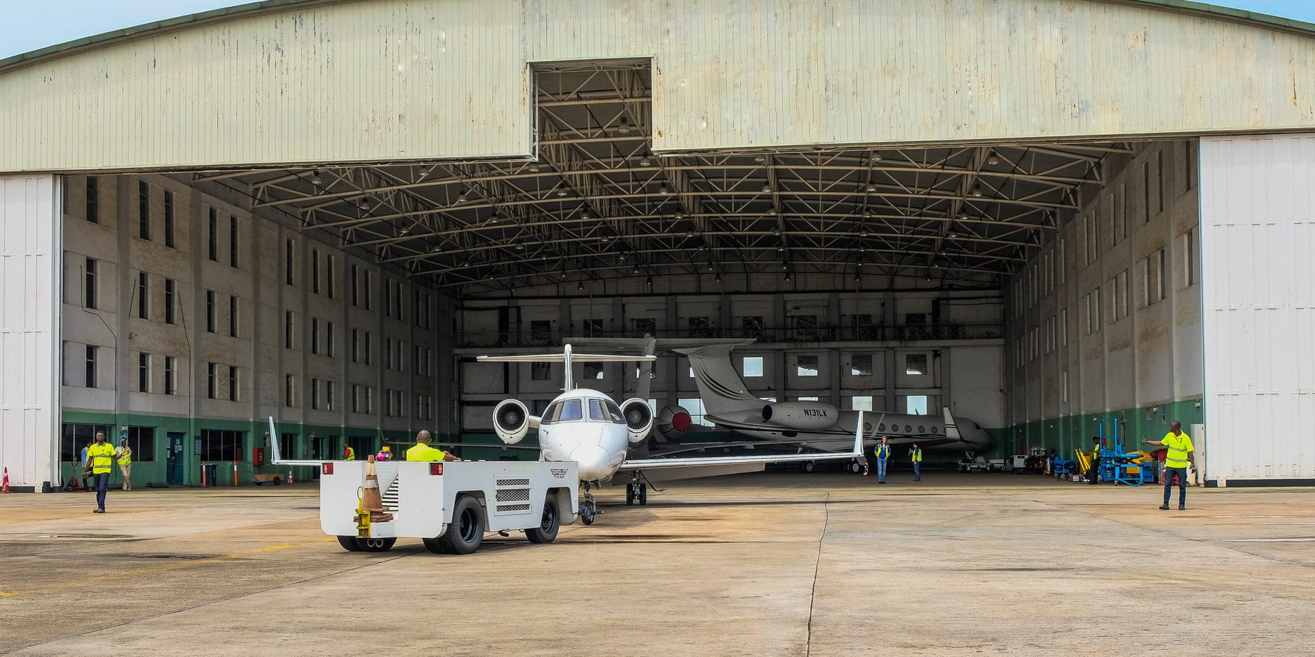 EAN Aviation ground crew towing a Dassault Falcon on the ramp at Murtala Muhammed International Airport, Lagos