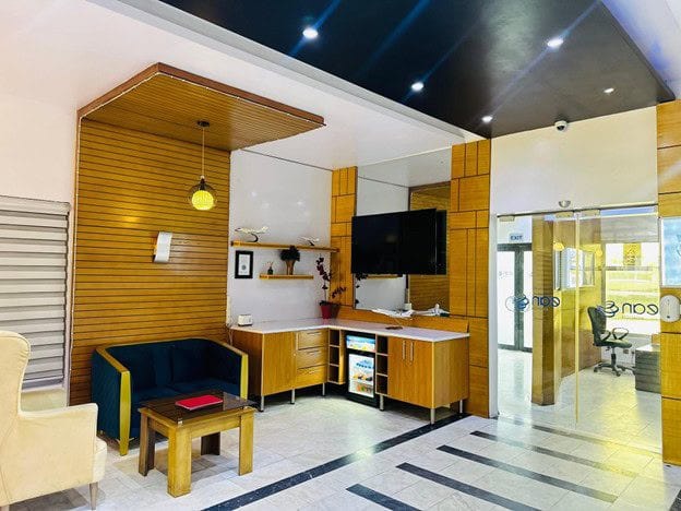 EAN’s passenger lounge, with wood panelling, armchairs and the ean Aviation branded glass entrance.