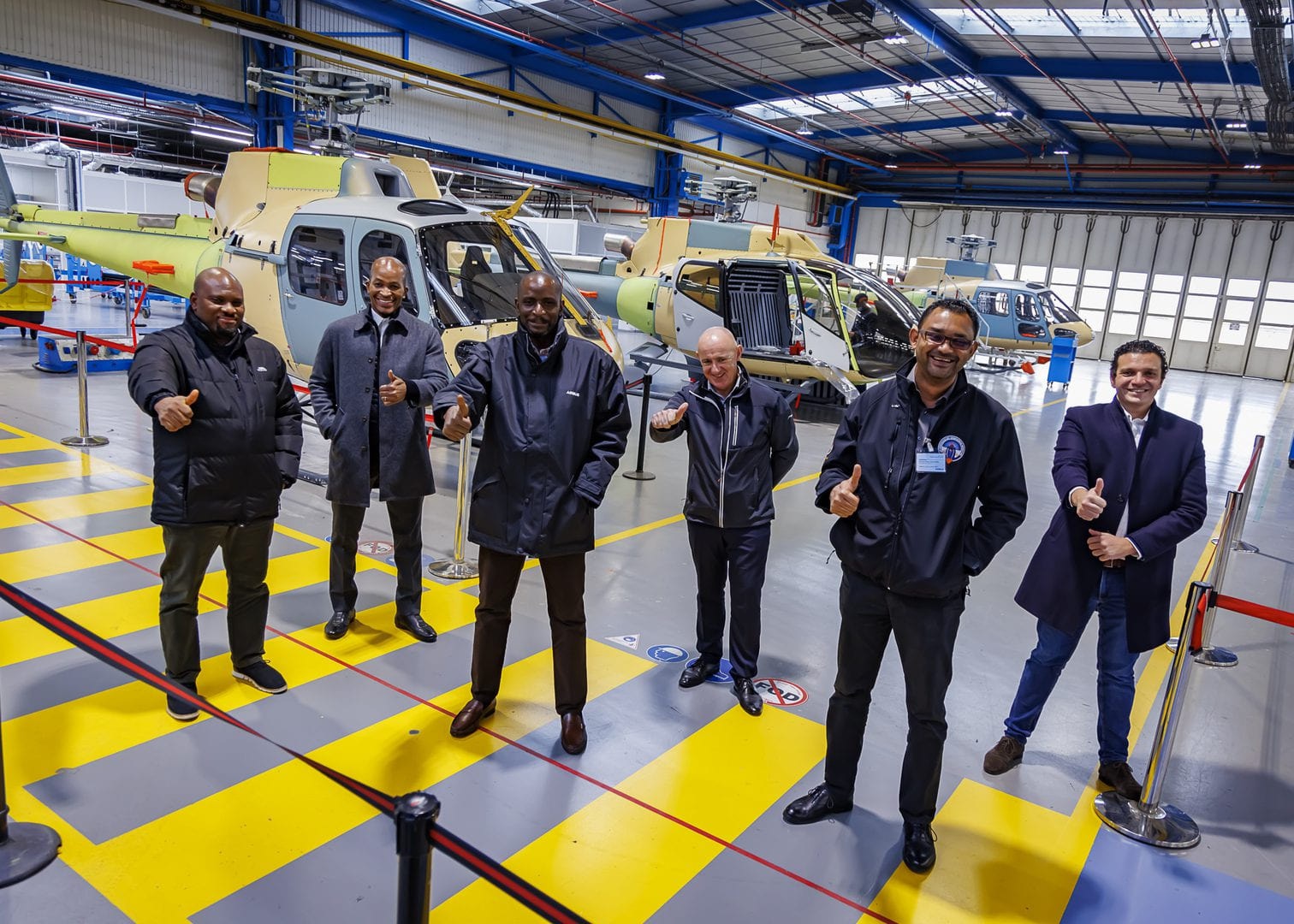 Tayo Aiyetan, in an Airbus jacket, with five colleagues in an Airbus Helicopters production hangar during EAN’s distributorship partnership.